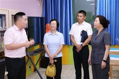 圖③：“小公民法律課堂”開講前，全國人大代表殷其龍（右二）、重慶市人大代表李自玲（左二）聽取楊家坪中學(xué)負責(zé)人關(guān)于未成年人思想教育工作情況的介紹。