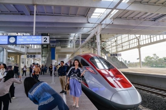  10月17日，在印度尼西亞萬隆德卡魯爾站，乘客在站臺上和雅萬高鐵高速動車組列車合影。新華社記者 徐欽 攝