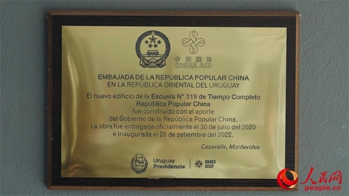 小學(xué)墻上懸掛的中國(guó)援助標(biāo)識(shí)。人民網(wǎng)記者 張若涵攝