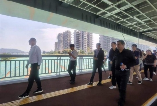 10月24日，2023“一帶一路”媒體合作論壇聯(lián)合采訪團(tuán)團(tuán)員走在清水塘大橋景觀通道上。本報(bào)記者 常雯宜攝