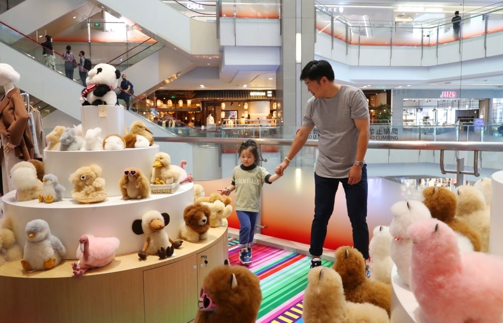 2023年11月2日，顧客在溫暖駝品牌專柜內(nèi)選購。連續(xù)六年參加進博會的秘魯羊駝制品品牌溫暖駝在上海市中心商場開設(shè)了專柜。新華社記者 方喆 攝