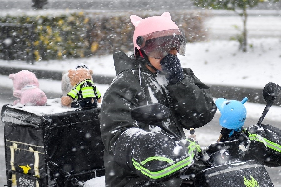 11月6日，在長春市街頭，一名外賣員在雪中騎行。新華社記者 許暢 攝