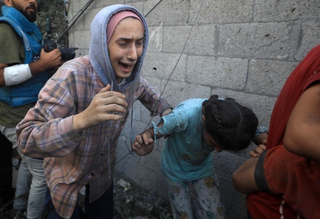 11月6日，人們從加沙地帶中部地區(qū)一處被炸難民營逃離。新華社發(fā)（亞西爾·庫迪攝）