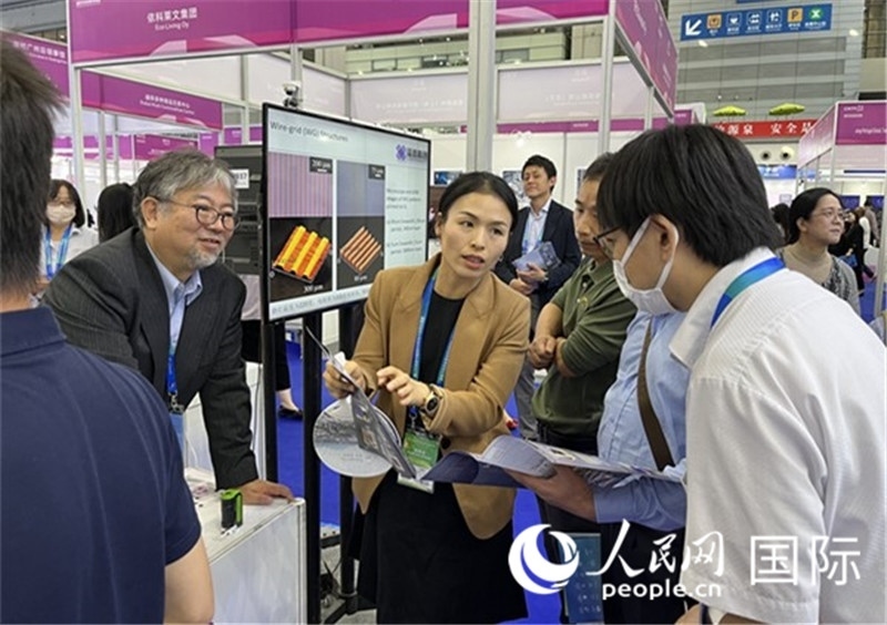 工作人員向參觀者介紹超級(jí)噴墨技術(shù)。（人民網(wǎng)記者 陳思攝）