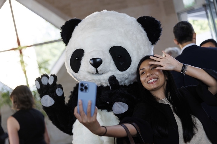 2022年8月24日，在美國華盛頓中國駐美國大使館，來賓與大熊貓玩偶合影。
