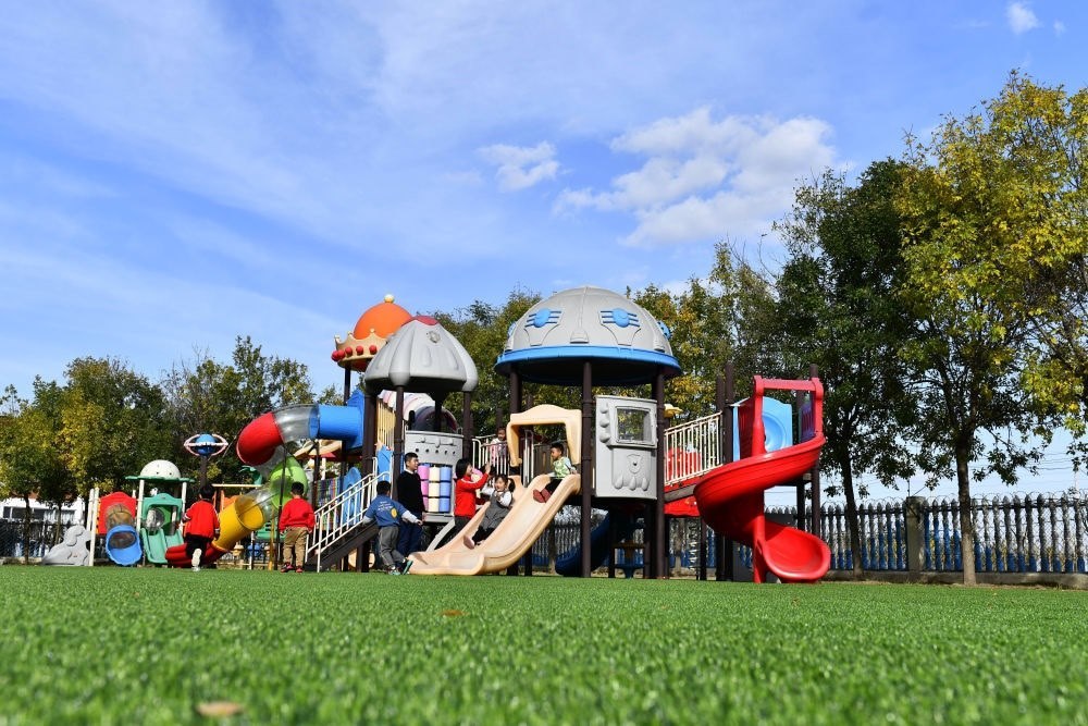 在山東省東營(yíng)市墾利區(qū)楊廟社區(qū)幼兒園，孩子們?cè)诶蠋煹膸ьI(lǐng)下進(jìn)行戶外活動(dòng)（2021年10月19日攝）。新華社記者 郭緒雷 攝