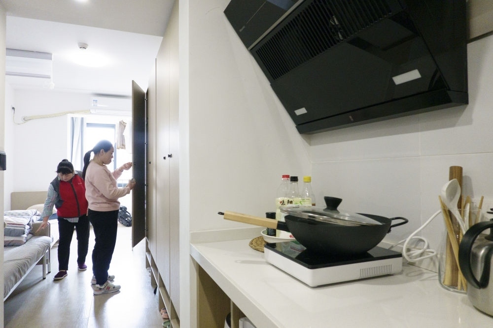 住戶在閔行區(qū)新時代城市建設(shè)者管理者之家收拾房間。