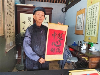 越南首都河內(nèi)文廟內(nèi)，阮明珠展示“中越心相近”書法作品。