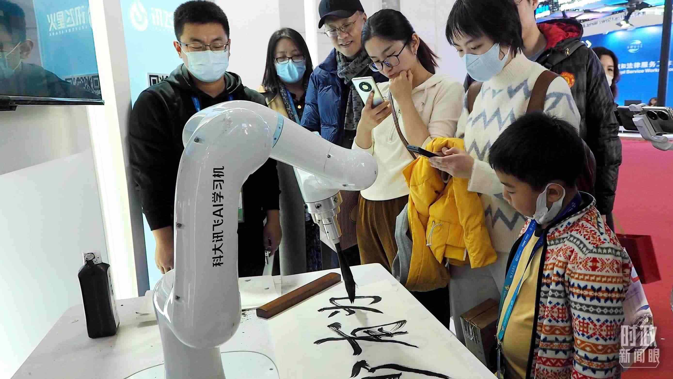 △觀眾在首屆鏈博會(huì)上體驗(yàn)AI書法機(jī)器人。