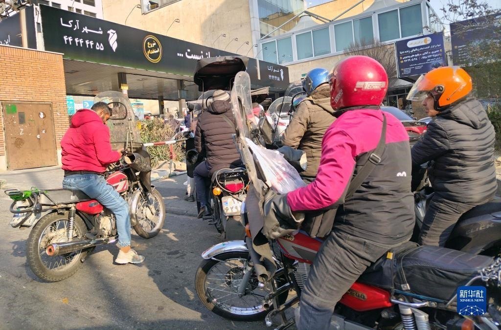 12月18日，摩托車在伊朗首都德黑蘭的一家加油站外等待加油。新華社記者 沙達(dá)提 攝