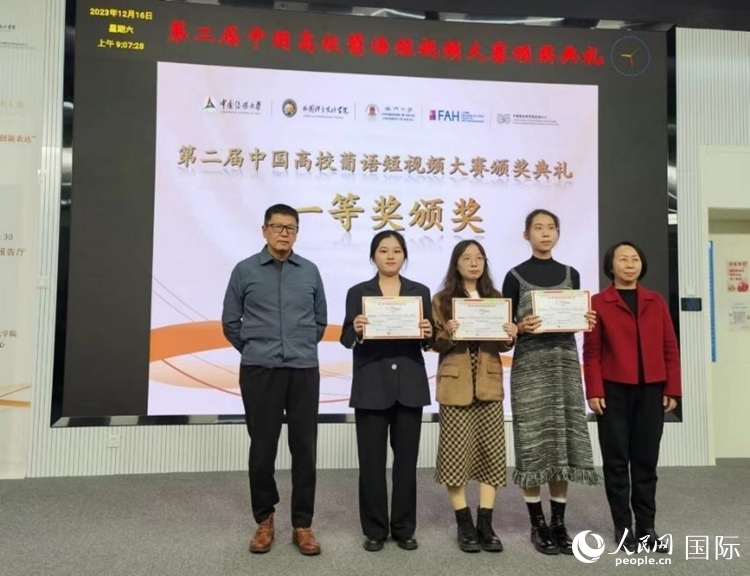 澳門大學(xué)中葡雙語教學(xué)暨培訓(xùn)中心主任姚京明（左一）和中國傳媒大學(xué)外國語言文化學(xué)院院長文春英（右一）為一等獎獲得者頒獎。人民網(wǎng)記者 魯揚(yáng)攝