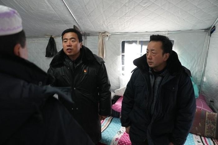 2023年12月22日，積石山縣大河家鎮(zhèn)大河村黨支部書記馬成忠（右二）在帳篷里和受災群眾交流。新華社記者 陳斌 攝