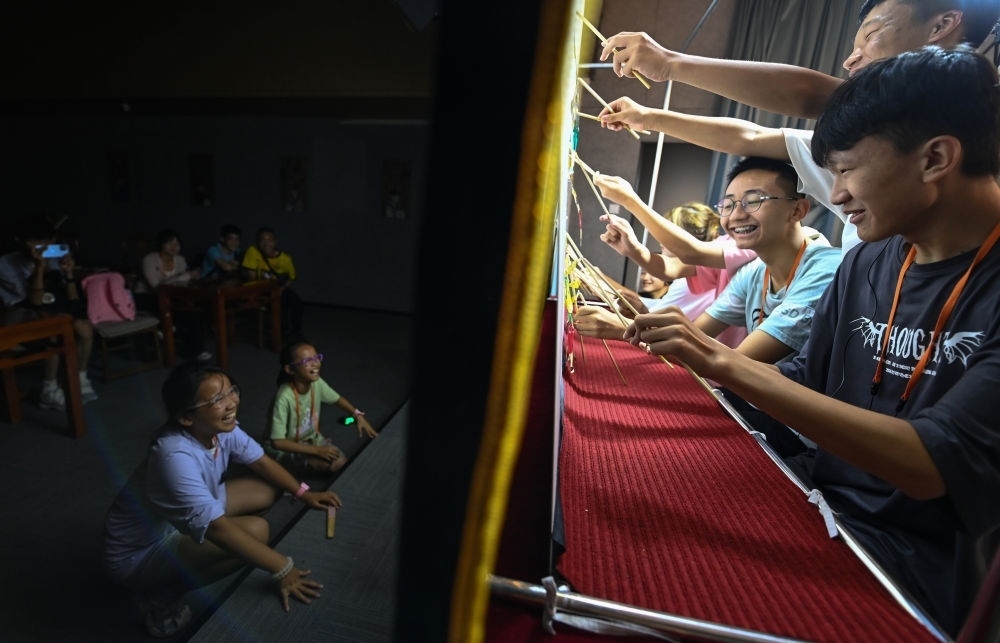 2023年8月8日，進(jìn)行暑期研學(xué)的學(xué)生在位于陜西省西安市的中國(guó)秦腔藝術(shù)博物館體驗(yàn)皮影戲演出。新華社記者 鄒競(jìng)一 攝