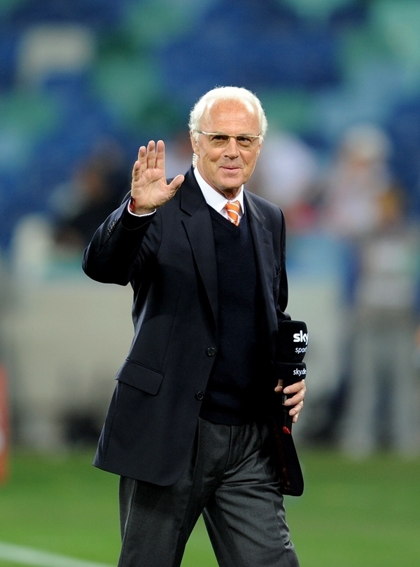 這是2010年7月7日，在南非德班舉行的2010年足球世界杯德國隊對陣西班牙隊的半決賽前，貝肯鮑爾接受電視臺采訪時和友人打招呼。新華社記者 王毓國 攝