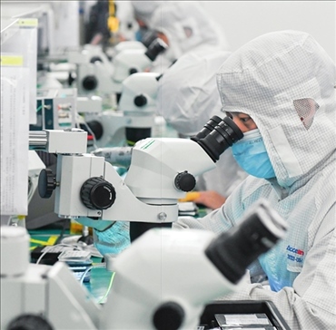 在位于武漢中國光谷的光電器件研發(fā)制造商——武漢光迅科技股份有限公司生產(chǎn)車間內(nèi)，技術(shù)人員在光模塊生產(chǎn)線作業(yè)（2023年4月11日攝）。程敏攝/本刊