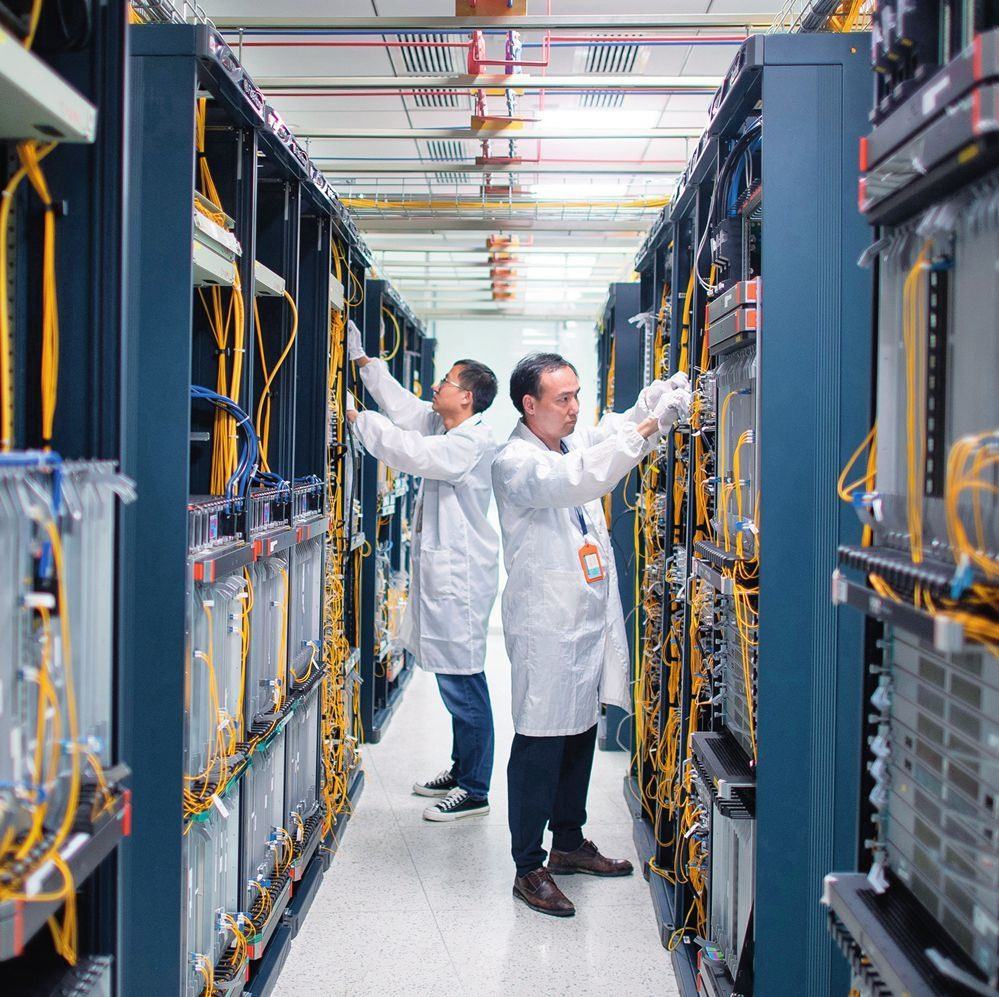 在位于武漢中國光谷的光電器件研發(fā)制造商——武漢光迅科技股份有限公司生產(chǎn)車間內(nèi)，技術(shù)人員在光模塊生產(chǎn)線作業(yè)（2023年4月11日攝）。程敏攝/本刊