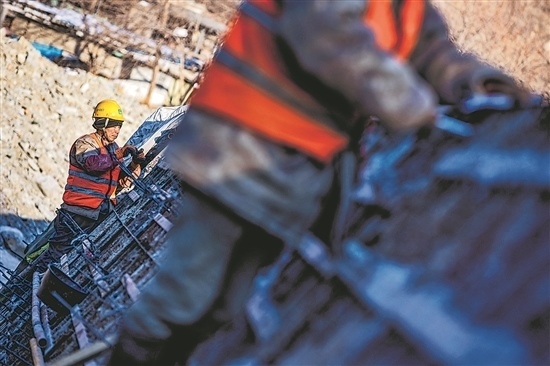 1月3日，房山區(qū)，工人正在雙泉河修筑堤壩。