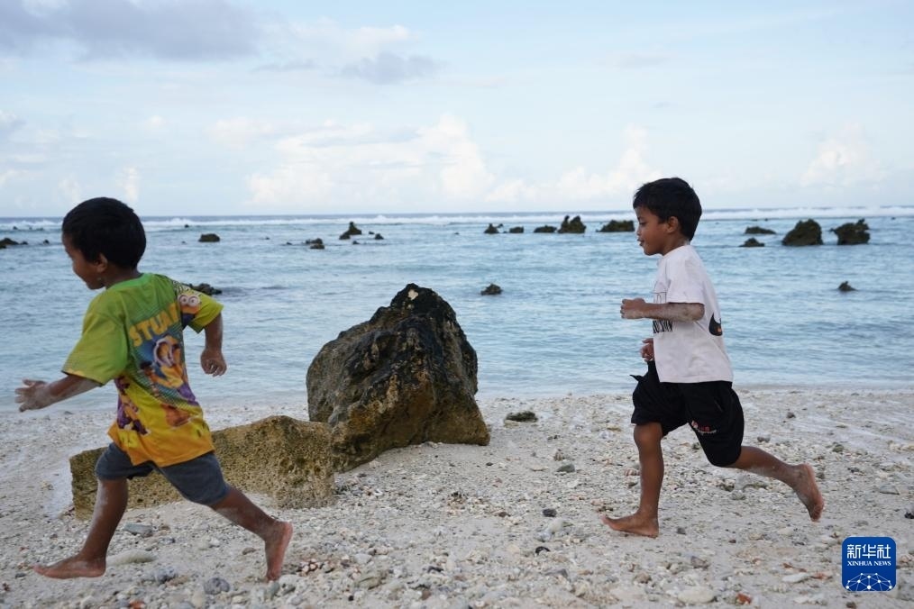 1月20日，兒童在瑙魯海邊嬉戲。新華社記者 王申 攝