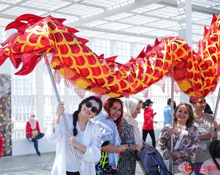 游客體驗舞龍。 人民網(wǎng) 塔里克·易卜拉欣攝