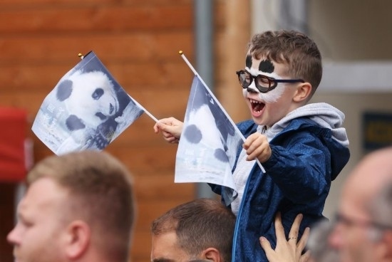  2023年7月26日，在法國(guó)圣艾尼昂市博瓦勒野生動(dòng)物園外，一名兒童等待送別熊貓“圓夢(mèng)”。新華社記者 高靜 攝