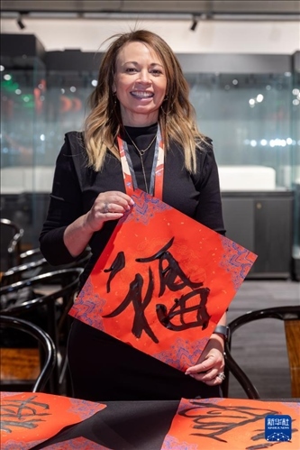 1月28日，在上海豫園舉行的民俗活動上，美國馬斯卡廷初中校長珍妮弗·李·弗里德利展示自己寫下的“?！弊帧?新華社記者 王翔 攝