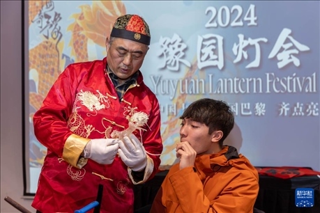 1月28日，在上海豫園舉行的民俗活動上，美國馬斯卡廷中學(xué)學(xué)生在非遺傳承人的指導(dǎo)下吹糖偶。 新華社記者 王翔 攝