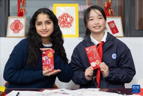 1月28日，美國馬斯卡廷中學(xué)學(xué)生（左）和復(fù)旦大學(xué)第二附屬學(xué)校學(xué)生展示互相送出的寫有寄語祝福的紅包。 新華社記者 王翔 攝