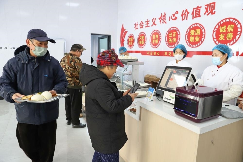 △2024年2月1日，市民在河北涿州市雙塔街道永濟秀園小區(qū)便民食堂內(nèi)購買午餐。