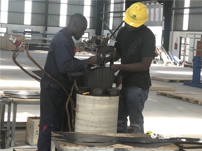 經(jīng)貿(mào)合作區(qū)廠房內(nèi)，當(dāng)?shù)毓と苏诰o張作業(yè)。人民網(wǎng)記者 黃培昭攝