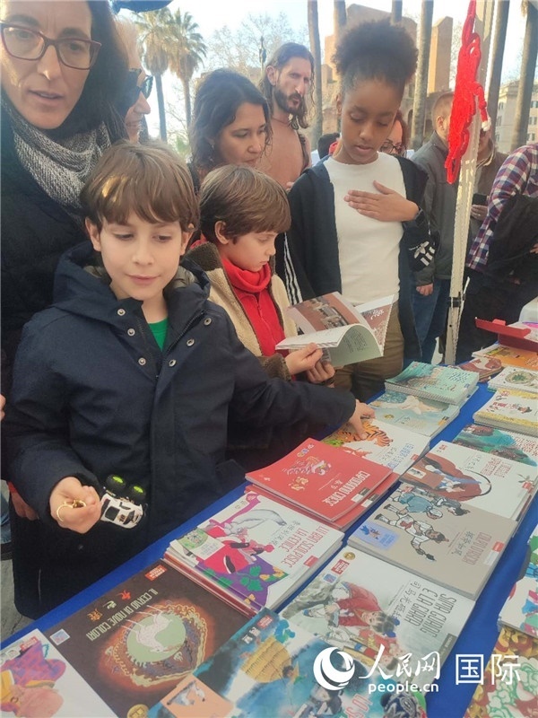 印刷精美的中國傳統(tǒng)文化叢書吸引了小游客的注意。人民網(wǎng)記者鄭彬攝