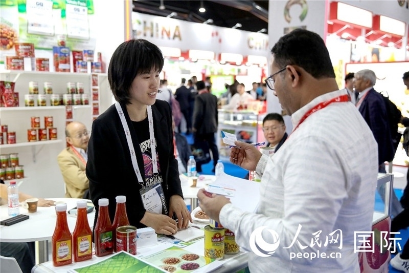 圖為中國參展企業(yè)代表與采購商交流。人民網(wǎng) 塔里克·易卜拉欣攝