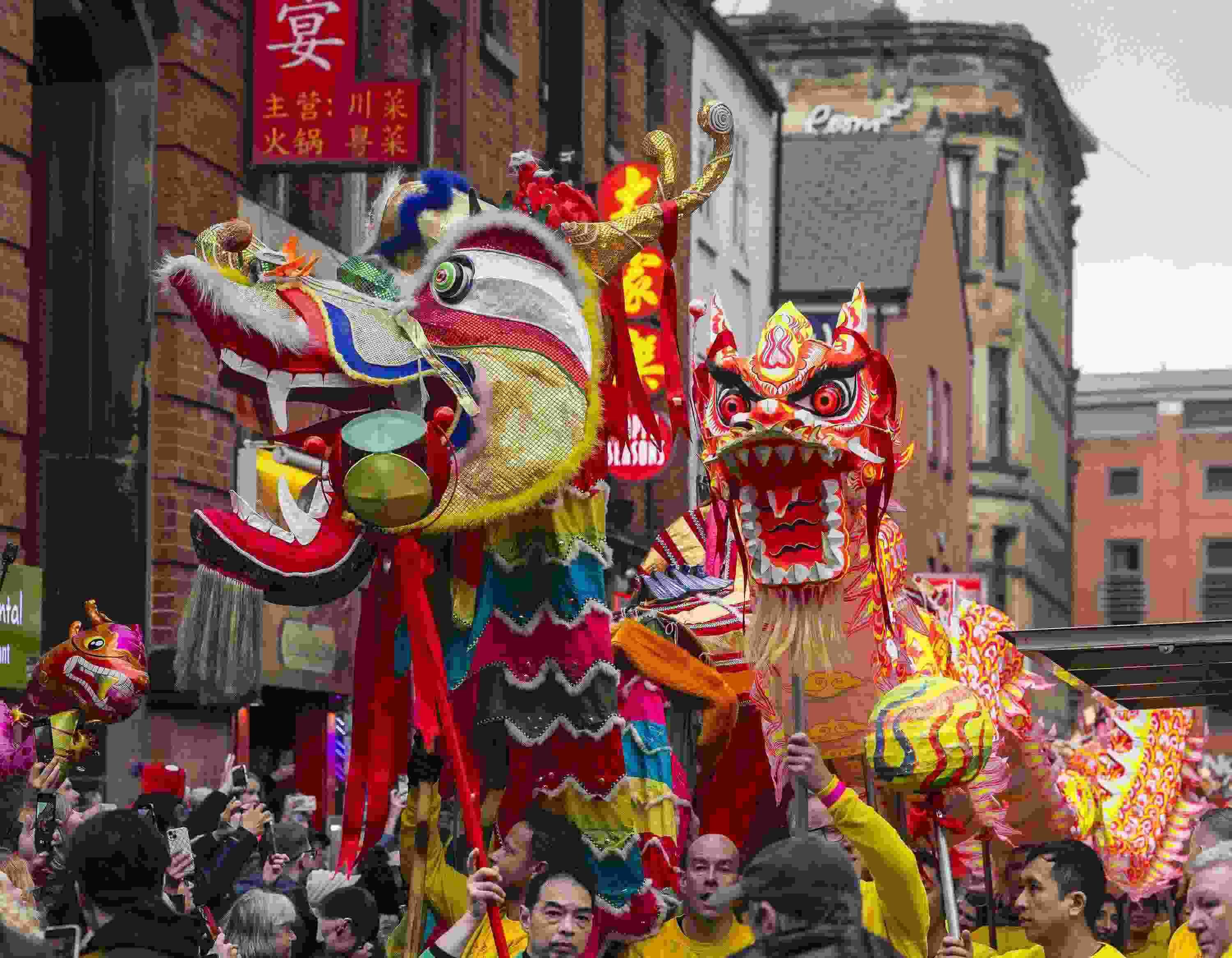 △ 當(dāng)?shù)貢r間2024年2月11日，英國曼徹斯特，表演者進(jìn)入中國城，參加中國農(nóng)歷龍年春節(jié)的慶?；顒印? width=