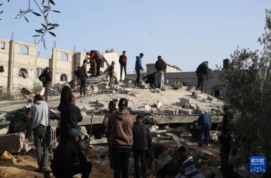  3月3日，在加沙地帶南部城市拉法，人們查看被以軍空襲破壞的建筑。新華社發(fā)（哈立德·奧馬爾攝）