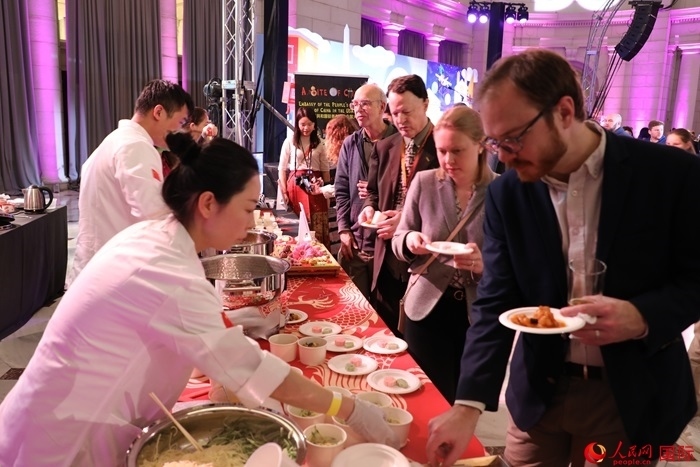 當(dāng)?shù)貢r間3月7日晚，華盛頓聯(lián)合車站廣場舉行駐美使團“使館主廚挑戰(zhàn)賽”。圖為當(dāng)?shù)孛癖娫谥袊古_前體驗中國美食。人民網(wǎng)記者 李志偉攝