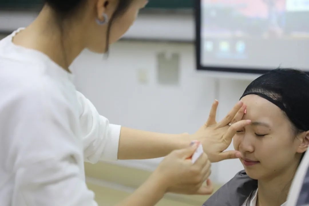 課堂上，一名學(xué)生在體驗(yàn)上戲妝。學(xué)校供圖