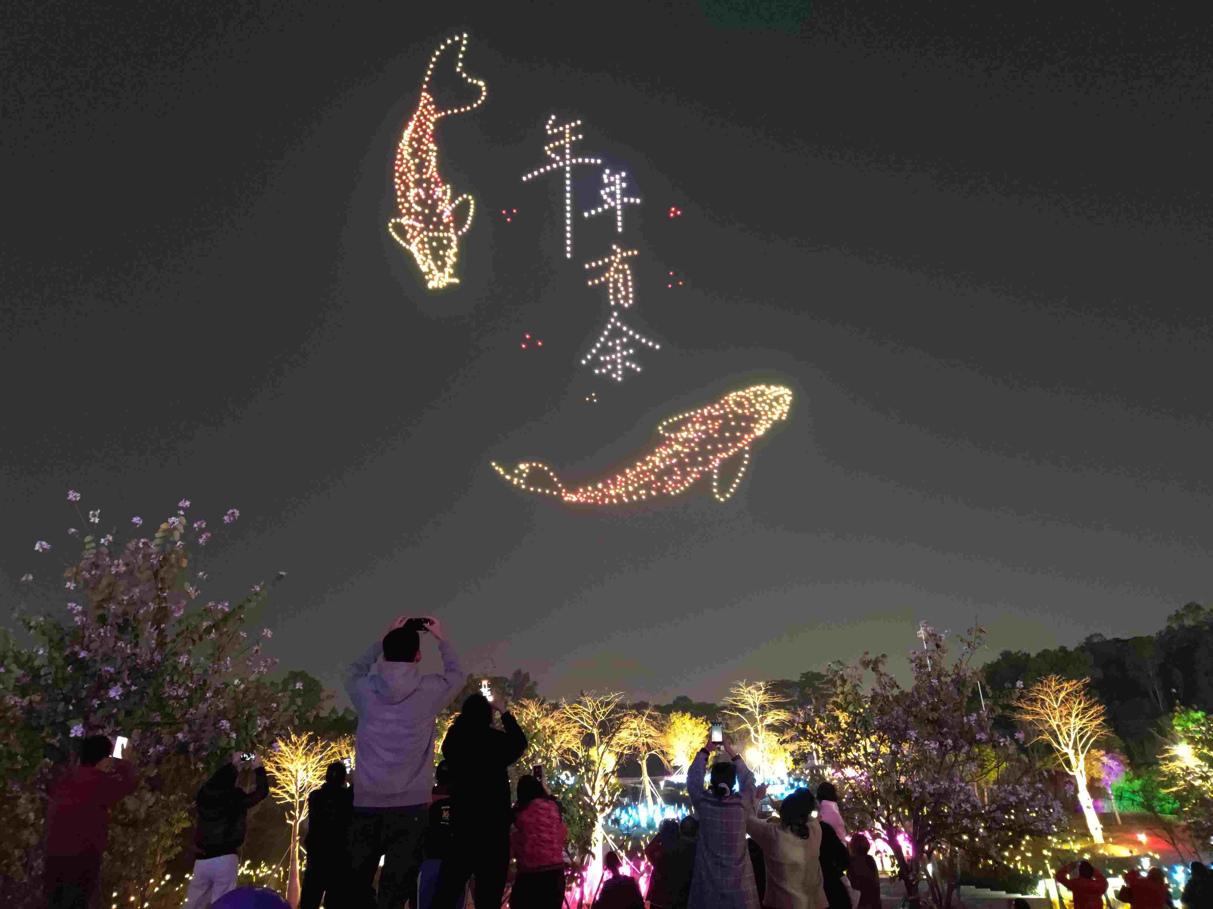 △ 2024年2月10日，深圳北站中心公園，春節(jié)主題無人機(jī)燈光秀引來眾多游客駐足觀看。