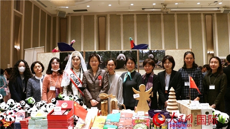 中國(guó)駐日本大使吳江浩夫人丁玥（左五）與使館人員在展位前合影留念。人民網(wǎng) 許可攝