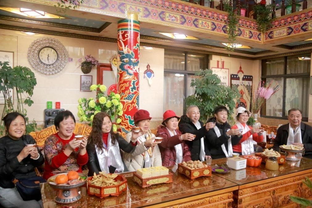 游客們?nèi)胱∶袼藓?，舉杯共飲酥油茶。新華社記者 邱星翔 攝