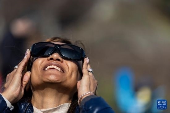 4月8日，一名女子在美國(guó)紐約州普拉茨堡觀看日食。新華社發(fā)（文森特·約翰遜攝）
