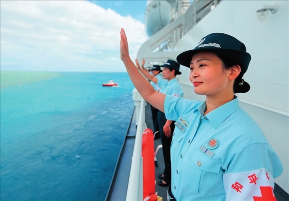 中國(guó)海軍“和平方舟”號(hào)醫(yī)院船結(jié)束訪問(wèn)湯加時(shí)，任務(wù)官兵中的文職人員向歡送人群揮手告別（2023年8月4日攝）。徐巍攝/本刊