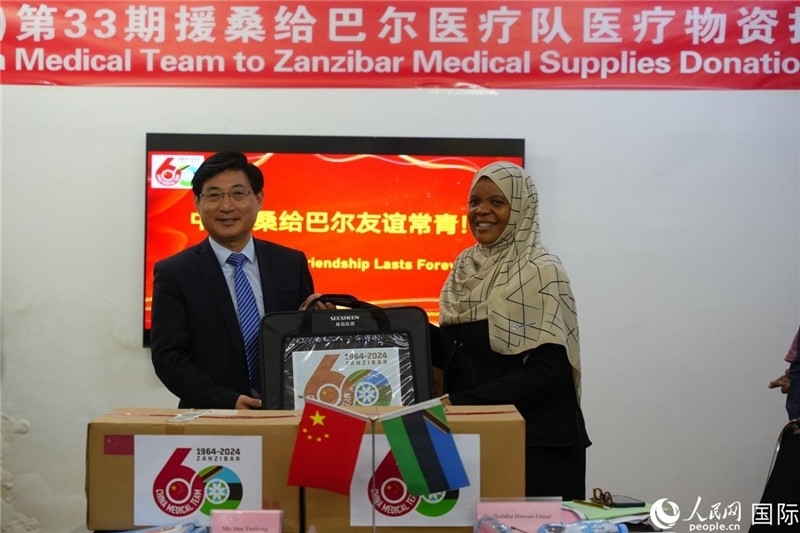 江蘇省蘇北人民醫(yī)院黨委書記束余聲捐贈物資與桑衛(wèi)生部首席秘書哈比巴。中國援桑醫(yī)療隊供圖