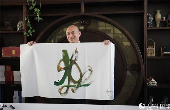 老撾駐華大使館三秘明君參加《五百筆·瀾湄合作》集體藝術(shù)創(chuàng)作。人民網(wǎng)王婧攝。