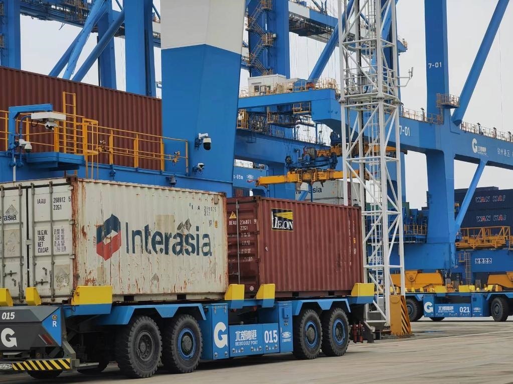 在欽州自動(dòng)化集裝箱碼頭，智能導(dǎo)引運(yùn)輸車在運(yùn)送集裝箱。新華社記者趙歡 攝