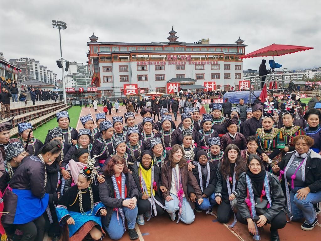 法國青年在“村超”賽場邊與參加表演的村民合影。新華社記者 羅羽 攝