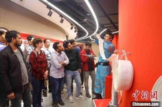 5月9日，工作人員指導(dǎo)留學(xué)生正確使用消防水帶。張鷹 攝