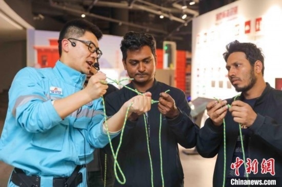 5月9日，工作人員指導(dǎo)留學(xué)生學(xué)習(xí)打繩結(jié)。張鷹 攝