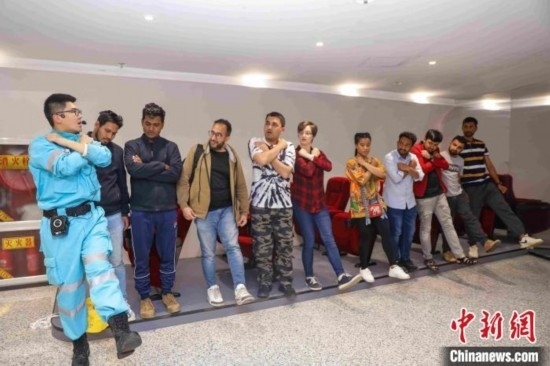 5月9日，工作人員指導(dǎo)留學(xué)生練習(xí)逃生技巧。張鷹 攝