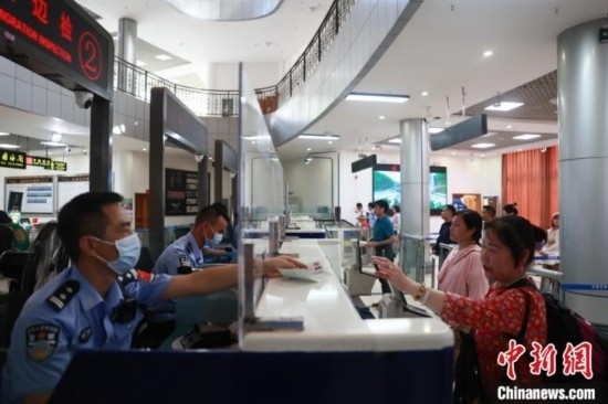 圖為旅客在磨憨口岸辦理通關(guān)手續(xù)。雷雨 攝