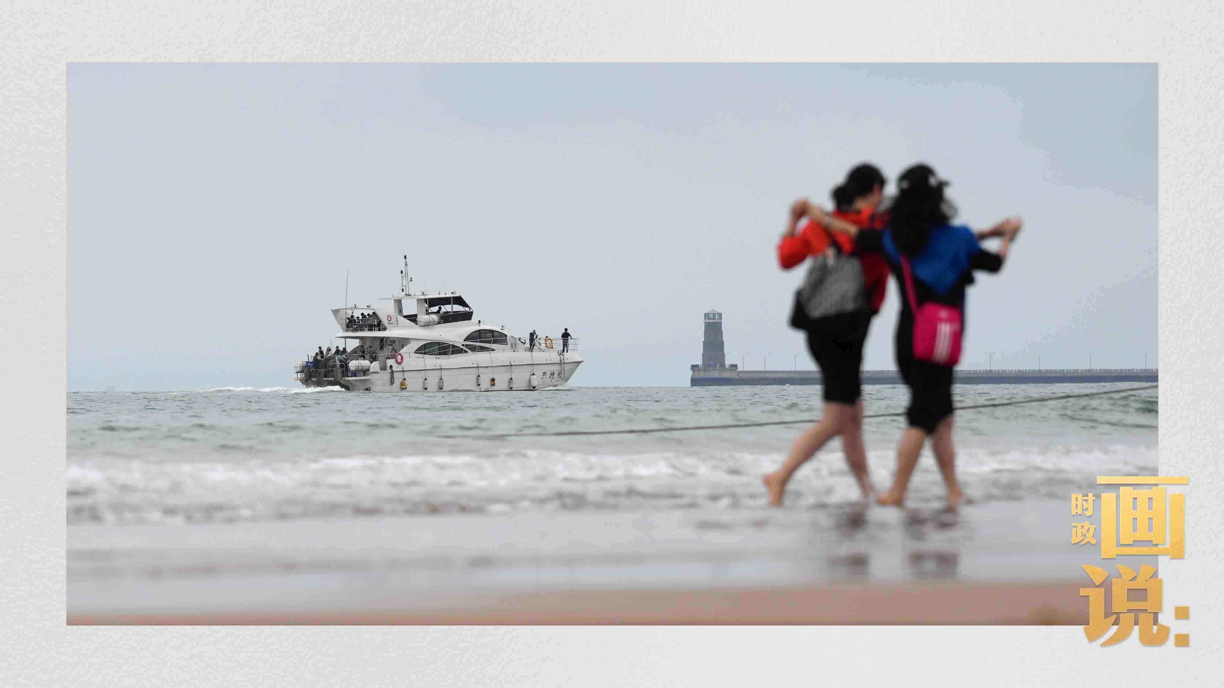 △日照陽光海岸綠道上的萬平口景區(qū)，一對(duì)游客在海浪中翩然起舞。