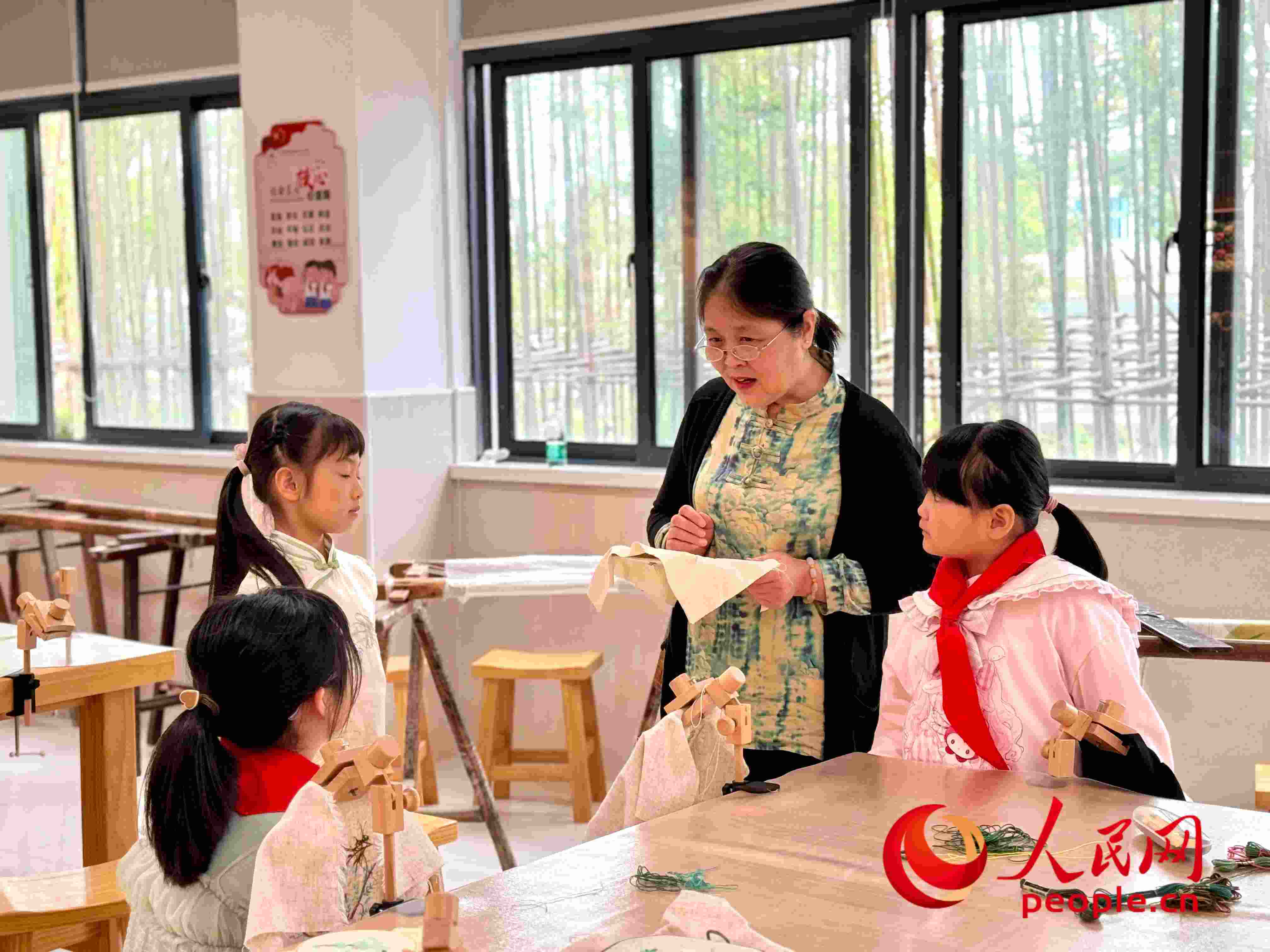 顧建珍（左三）在教孩子們刺繡知識(shí)。人民網(wǎng) 周靜圓攝